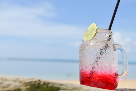 red spirit drink lemon soda cocktail on the beachの写真素材
