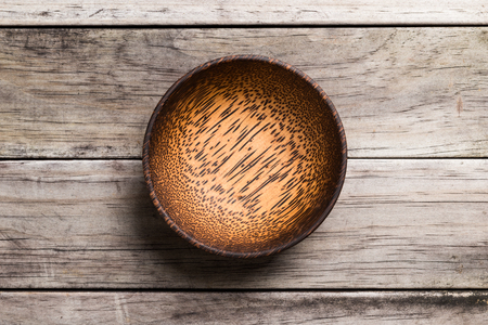 Empty Wooden Bamboo Bowl isolated on wood Background with Real Shadow. Top View with Copy Space for Textの写真素材