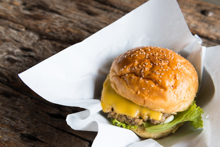 Homemade beef burger with melted cheese  on wooden backgroundの写真素材