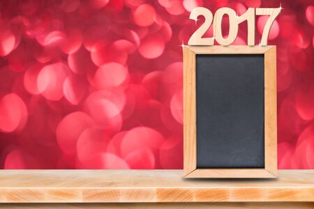 Blackboard menu with on wooden table with blurred bokeh background, And copy space for adding your content happy new year 2017の写真素材