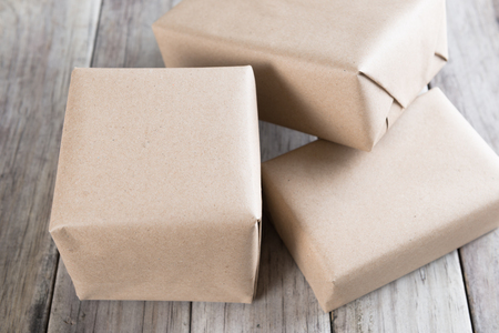 Cardboard box on a wooden background, Brown mail package parcel wrap deliveryの写真素材