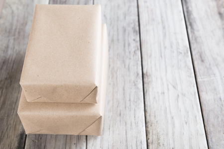 Cardboard box on a wooden background, Brown mail package parcel wrap deliveryの写真素材