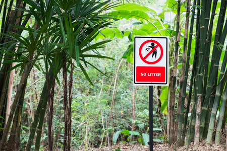 Red no littering sign green wood backgroundの写真素材