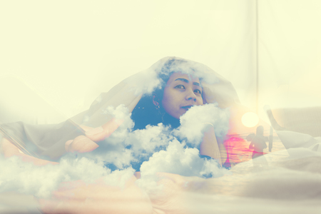 Asian women relax and laying on the bed in the morningの写真素材