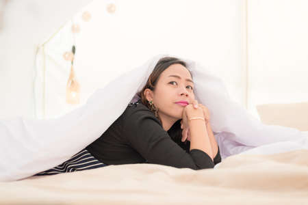 Asian women relax and laying on the bed in the morningの写真素材