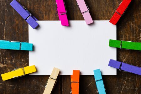 White blank card with colorful clip  wood backgroundの写真素材