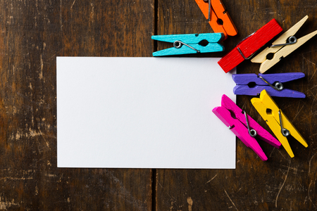 White blank card with colorful clip  wood backgroundの写真素材