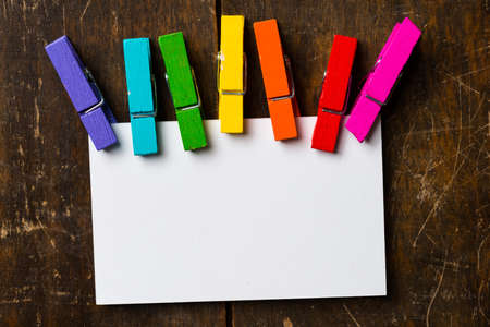White blank card with colorful clip  wood backgroundの写真素材