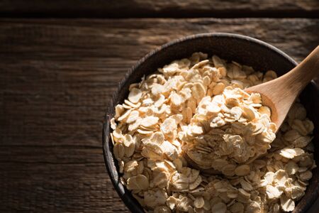 Dry rolled oat flakes oatmeal on old wooden tableの写真素材