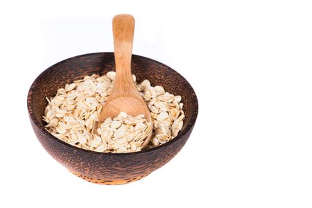 Dry rolled oat flakes oatmeal in bowl isolated on white backgroundの写真素材