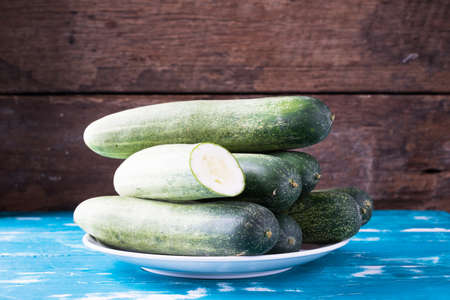 Fresh cucumbers in plate on wood table. Green cucumber from Thailand.の写真素材