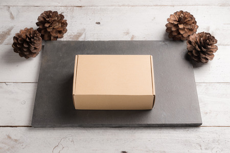 Cardboard box on a white wooden background christmas gift conceptの写真素材