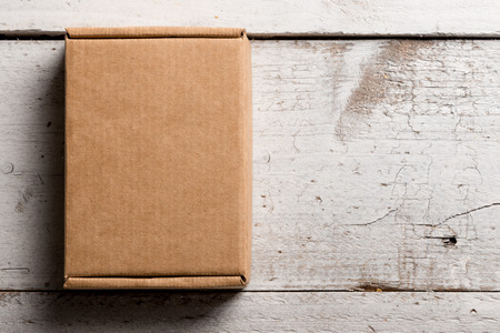 Cardboard box on a white rustic wooden backgroundの写真素材