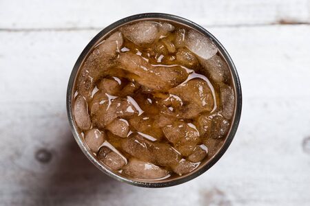 Cola drink glass on white wooden table