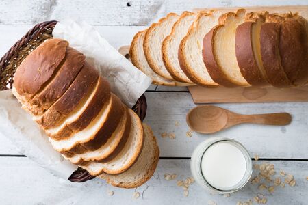 Fresh homemade  baked bread and sliced bread on rustic white wooden table topviewの写真素材