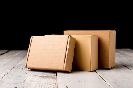 Cardboard box on a white rustic wooden background