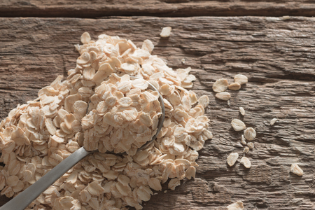 Dry rolled oat flakes oatmeal on old wooden table retro filterの写真素材