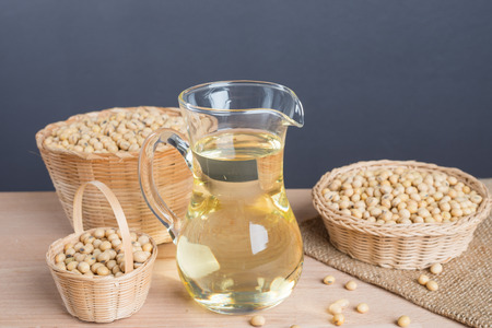 Soybean in basket and soybean oil in jar on wooden backgroundの写真素材