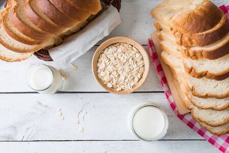 Fresh homemade  baked bread and sliced bread with milk on rustic white wooden table topviewの写真素材