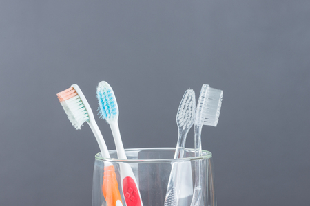 Toothbrush old and new in glass on gray backgroundの写真素材