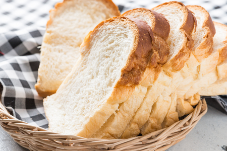 Fresh homemade  baked bread and sliced bread on rustic white wooden tableの写真素材
