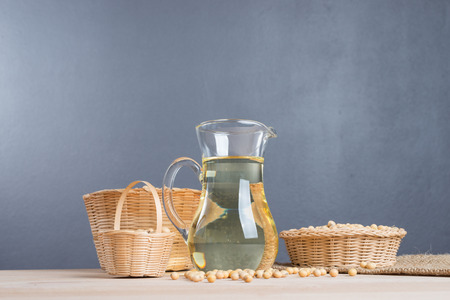 Soybean in basket and soybean oil in jar on wooden backgroundの写真素材