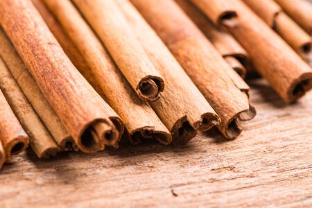 Cinnamon sticks spice closeup on wooden  background. Texture of cinnamon sticks.