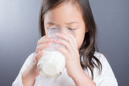 Asian kid cute girl age 6 year happy to drink milkの写真素材