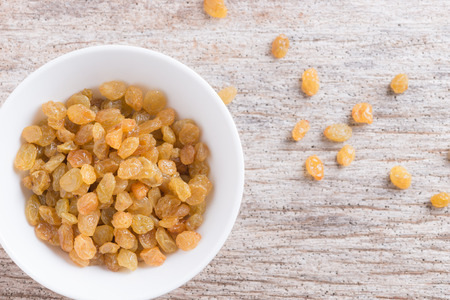 Dried yellow raisin fruits on  wooden backgroundの写真素材