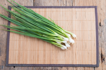 Pile of fresh spring onion on wooden tableの写真素材