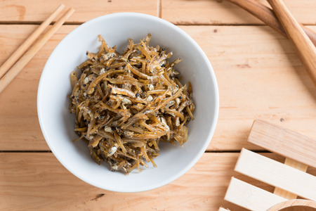 Fried sweet Anchovies in bowl on wooden backgroundの写真素材