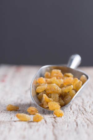 Dried yellow raisin fruits on  wooden backgroundの写真素材