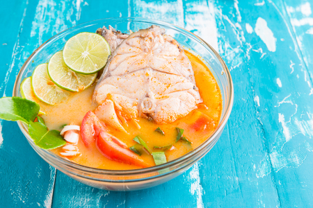 Spicy Sour Soup with fish with mushroom and tomato on wooden table , Thai local food , Tom Yum Plaの写真素材