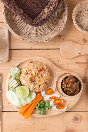Fried rice with Shrimp paste sauce , salted egg and sweet pork on wooden backgroundの写真素材