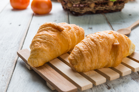 Tasty croissants on white wooden backgroundの写真素材