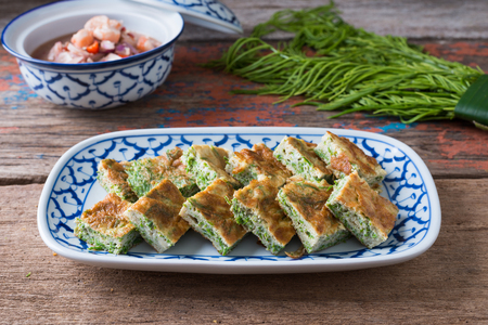 Thai food, Acacia Pennata Omelette and Shrimp-paste sauce, vegetables on wooden table background.の写真素材
