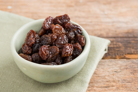 Raisins on a wooden background.の写真素材