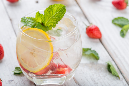 Strawberry juice and lemon soda juice mixed with soda on wooden backgroundの写真素材