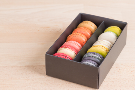 Colorful macaroons. Sweet macarons in the box dark background .の写真素材
