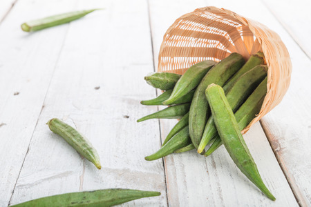 Fresh Green Okra ( Abelmoschus esculentus ) on white wooden backgroundの写真素材