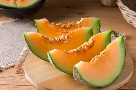 Melon slice on wooden table backgroundの写真素材