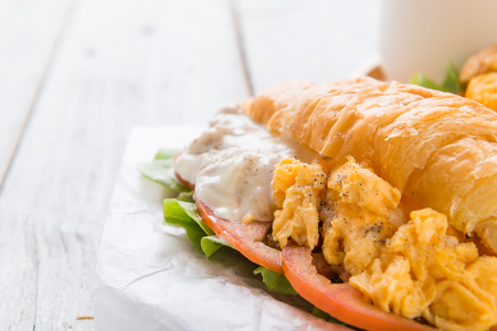 Breakfast Croissant stuffed scrambled eggs and tuna on wooden backgroundの写真素材