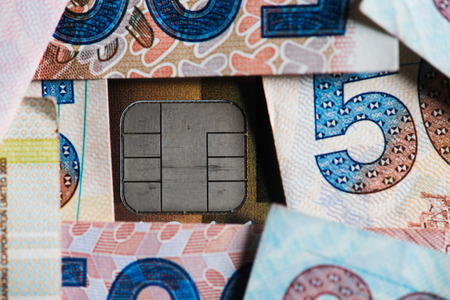 Pile of many Hong Kong Dollar banknotes and chip card as money technology background.の写真素材