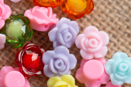Colorful flower plastic beads on wooden background