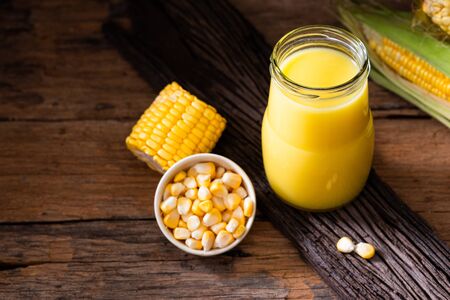 Fresh sweet corn juice (corn milk) and corn on wooden backgroundの写真素材