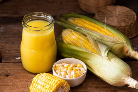 Fresh sweet corn juice (corn milk) and corn on wooden backgroundの写真素材