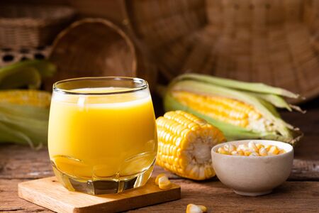 Fresh sweet corn juice (corn milk) and corn on wooden backgroundの写真素材