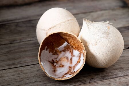 Peeled coconut  on woodden table backgroundの写真素材