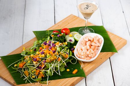 Fresh salad plate with shrimp, salmon, tomato and mixed greens  on wooden background close up. Healthy food. Clean eating.の写真素材