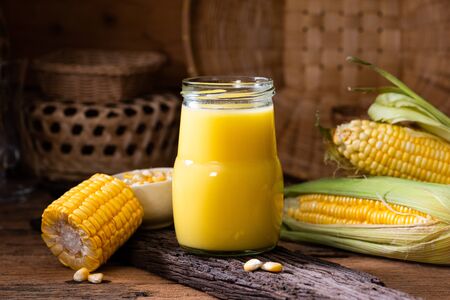 Fresh sweet corn juice (corn milk) and corn on wooden backgroundの写真素材